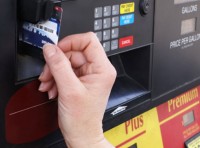 image of hand paying at gas pump with credit card
