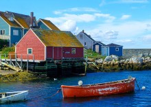 image of boat anchored along the shoreline with houses in the background